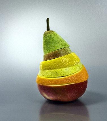 Fruits empilés formant une tour : poire, banane, orange et pomme