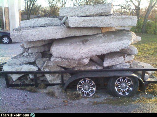 Camion surchargé transportant des blocs de pierre massive empilés.