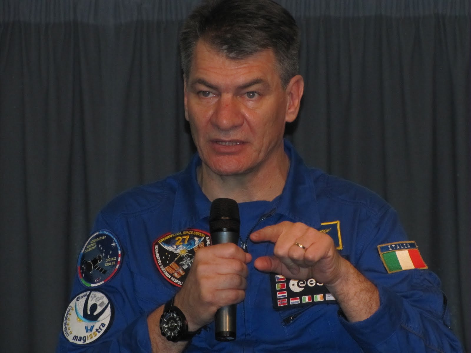 Spationaute Paolo Nespoli en combinaison bleue lors d'une présentation
