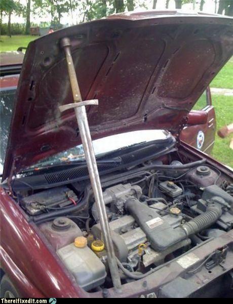 Moteur de voiture ouvert avec un bâton de bois servant de jauge d'huile