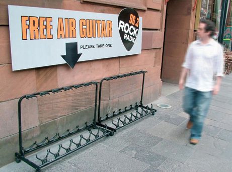 Pancarte « Air guitar gratuit » avec flèche vers râtelier