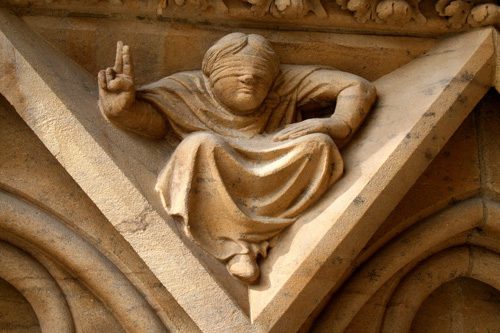 Sculpture en pierre d'un enfant pointant du doigt vers le haut