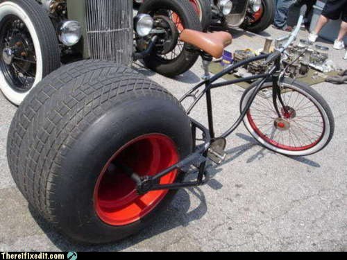 Grande roue peinte en rouge à côté d'une roue de vélo pour comparer les tailles