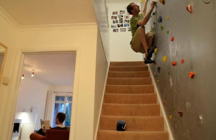 Enfant escaladant un mur à prises colorées dans escalier