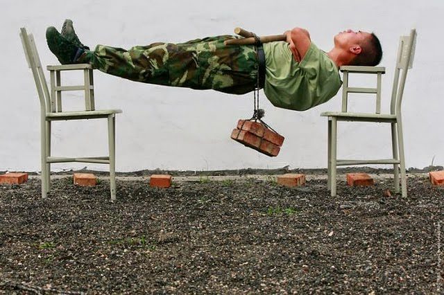 Soldat en tenue militaire allongé se reposant sur deux chaises
