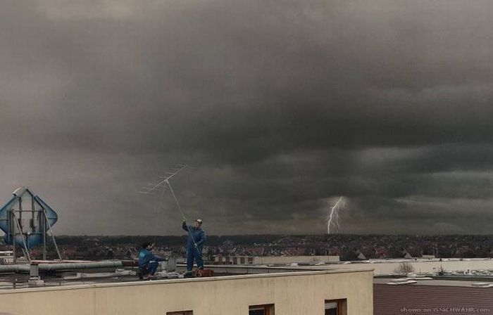 Orage violent avec éclair en arrière-plan au-dessus d'une ville, deux personnes sur un toit