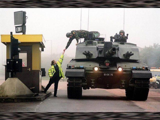 Militaire saluant devant un char de combat au péage