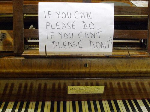 Clavier de piano ancien avec pancarte manuscrite: « Si vous pouvez veuillez faire / Si vous ne pouvez pas ne faites pas »