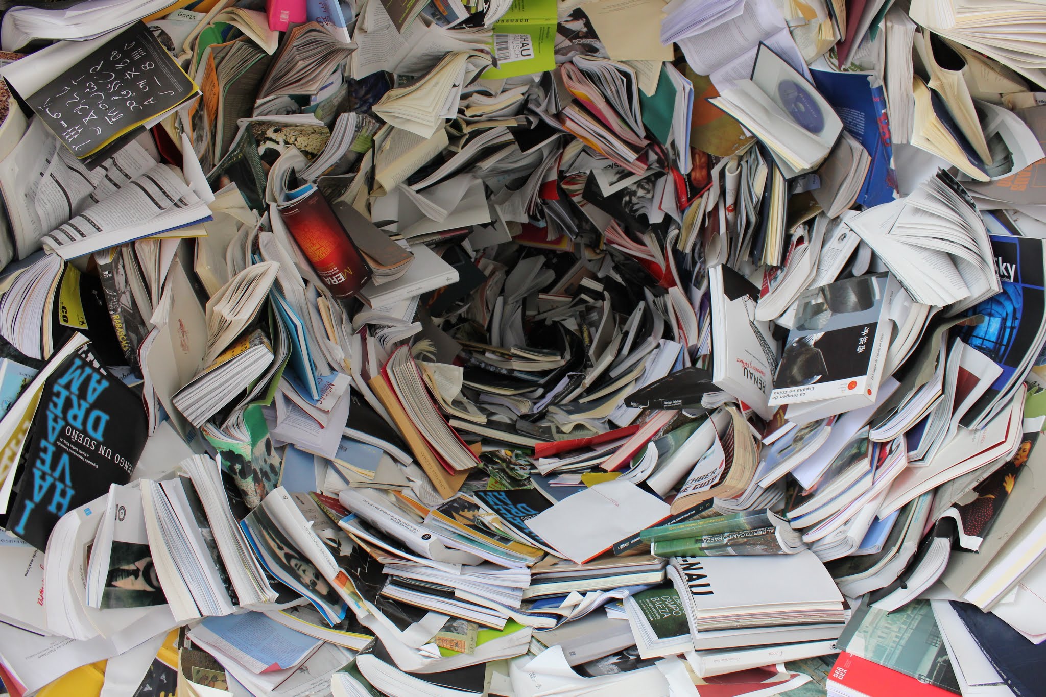 Pile désorganisée de livres, cahiers et documents entassés