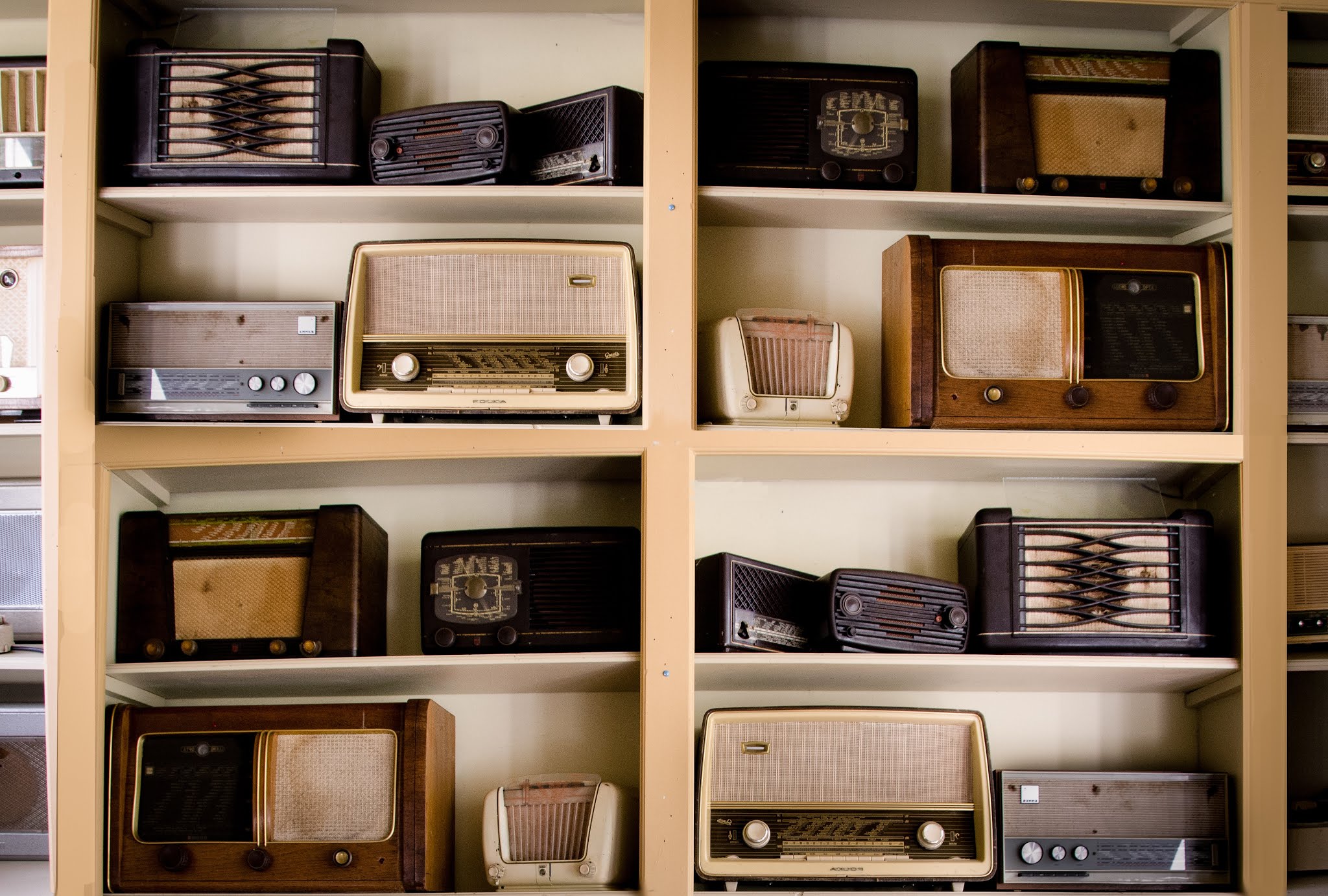 Étagères de bois affichant une collection de postes de radio vintage