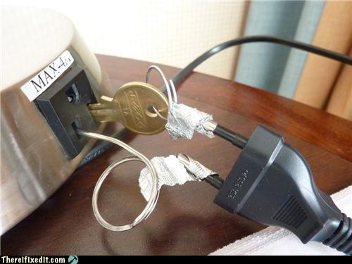 Détail d'une prise électrique bricolée avec une clé de coin en guise de connecteur