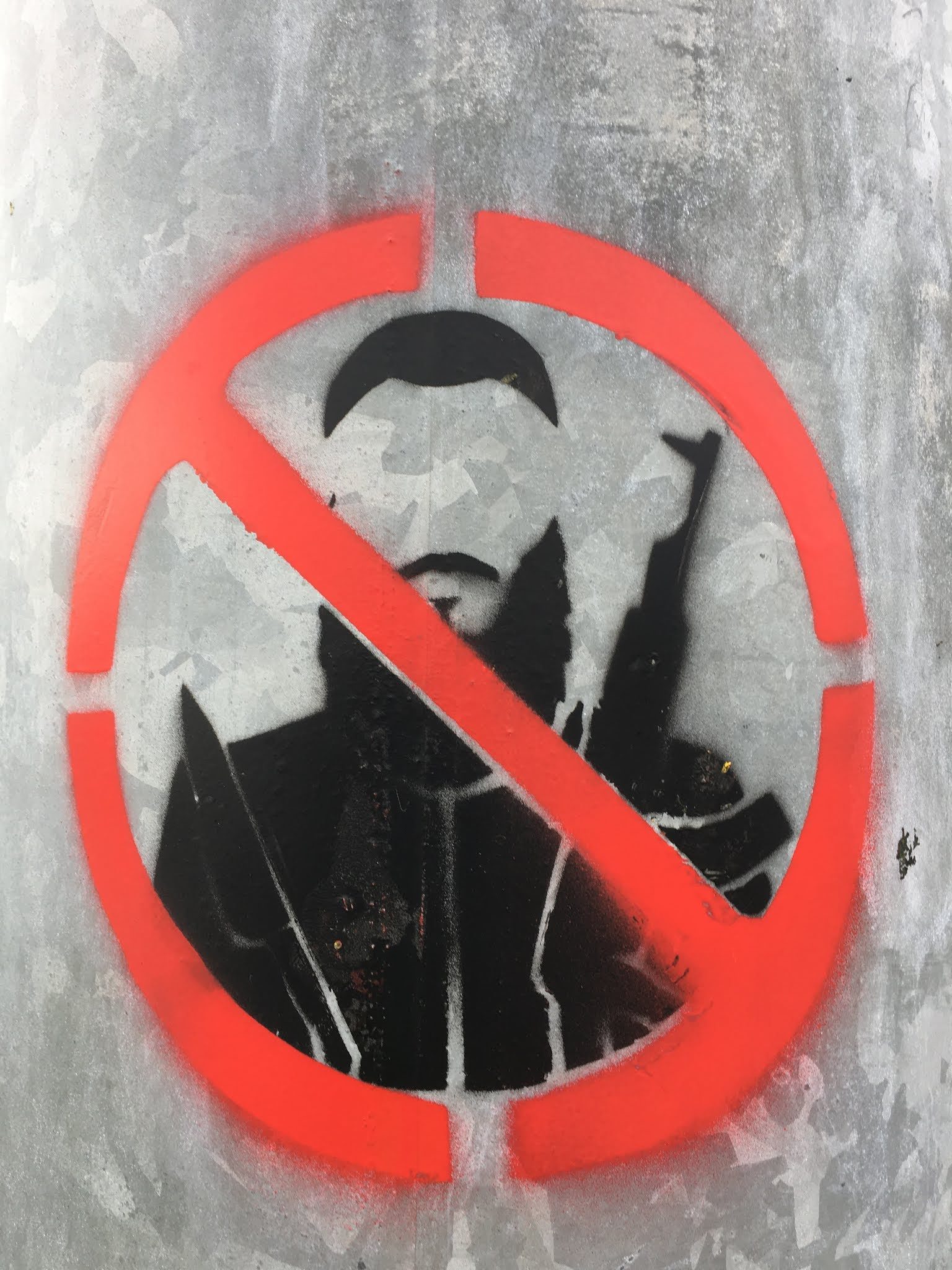 Street art : portrait stencilisé barré d'un cercle rouge