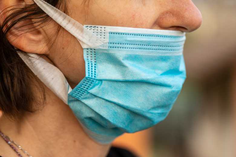 Profil de personne portant un masque chirurgical bleu