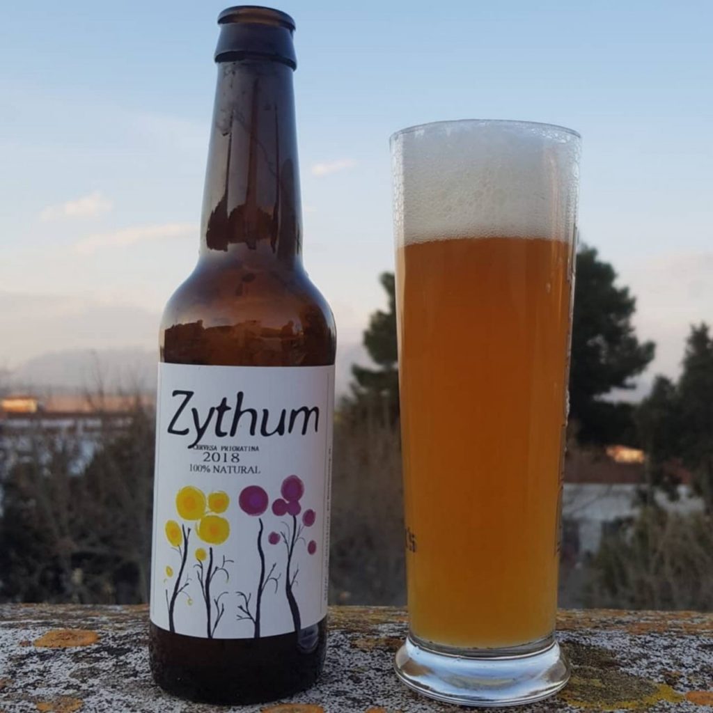 Bouteille de bière Zythum 100% naturel avec motifs floraux et verre de bière dorée