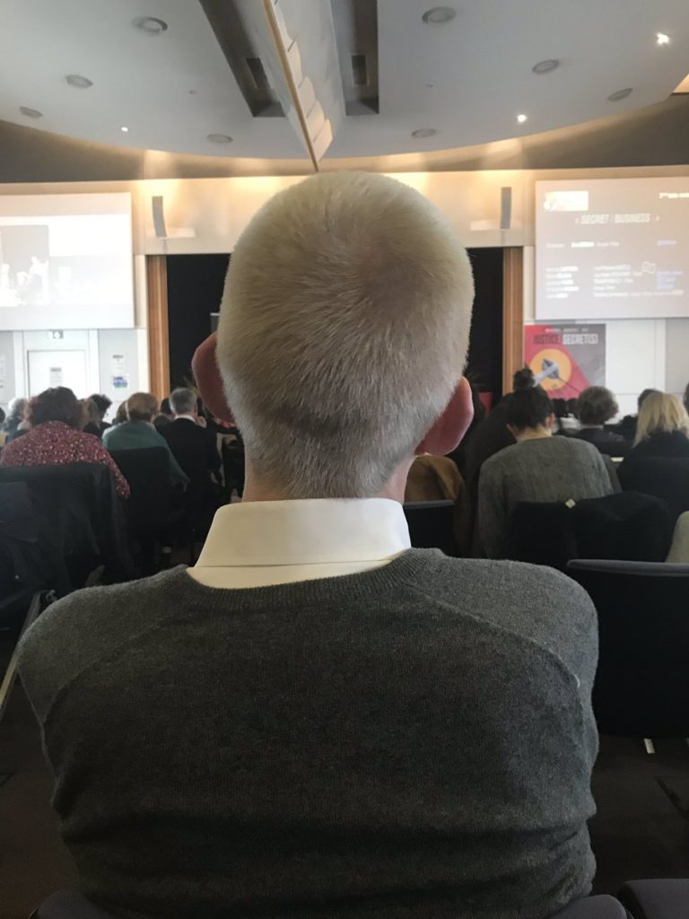 Spectateur aux cheveux gris lors d'une présentation de conférence