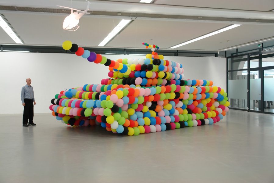 Installation artistique: char d'assaut géant en ballons colorés en galerie