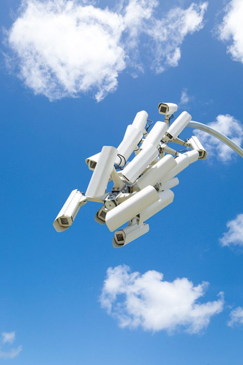 Caméras de surveillance blanches flottant dans le ciel bleu