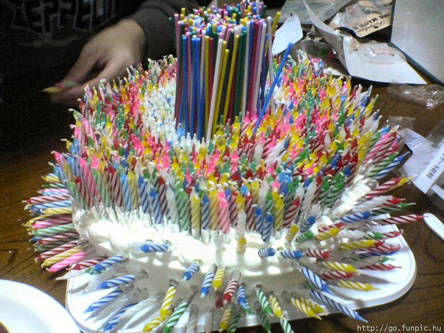 Main tenant gâteau d'anniversaire en spirale, garni de bougies multicolores