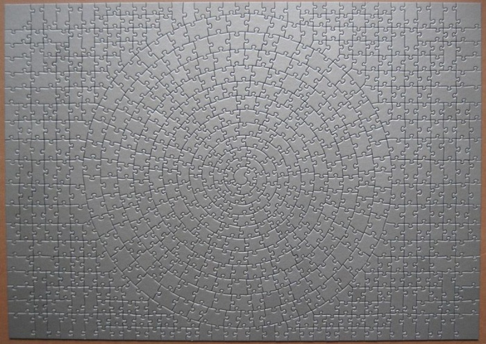 Puzzle gris complet formant un motif géométrique en spirale concentrique